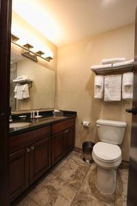 a bathroom with a toilet and a sink and a mirror at Arrow Hotel in Broken Bow