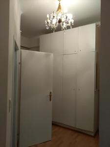 ウィーンにあるWohnung in Wienの白いキャビネットとシャンデリアが備わる客室です。