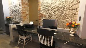 a room with a stone wall with a desk with a television at Alqueria de Carrion Hotel Boutique in Atlixco