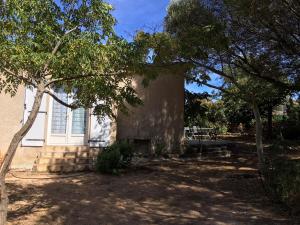 un bâtiment avec des arbres devant lui dans l'établissement Gîte à Poggiale de Figari, à Figari