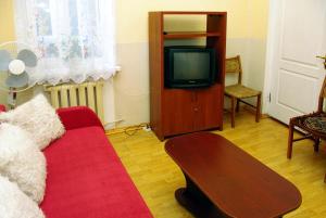salon z czerwoną kanapą i telewizorem w obiekcie Большая комната w Odessie
