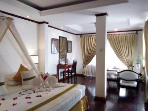 a bedroom with a bed and a table and chairs at Emerald Sea Resort in Ngwesaung