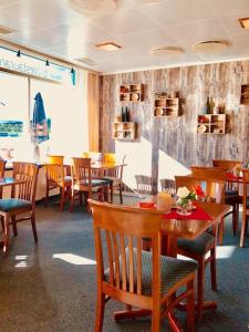 Bjerkvik Hotell في بجيركفيك: غرفة طعام مع طاولات وكراسي خشبية