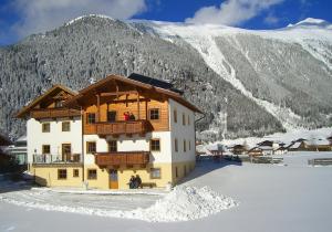 a building in the snow with a mountain in the background at Haus Lärchenwald in Niederthai