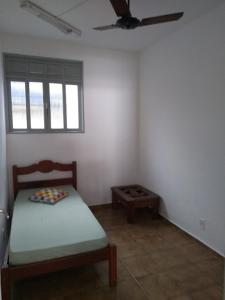 a small room with a bed and a window at Casa na orla da Praia do Forte in Cabo Frio