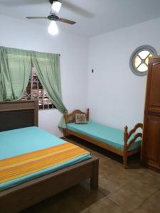 a bedroom with two beds and a window at Casa na orla da Praia do Forte in Cabo Frio
