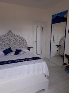 a bedroom with a white bed and a mirror at Hill Valley View in Vico Equense