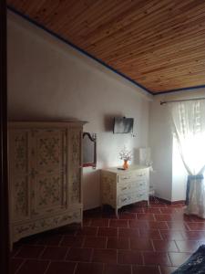アヴィスにあるCasa do Montinhoのベッド、ドレッサー、窓が備わる客室です。