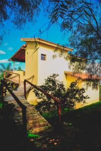 a yellow building with a staircase in front of it at Pousada Caminho da Serra in São Roque de Minas