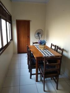 a dining room table with chairs and a fan on it at Casa na Praia do Forte in Cabo Frio
