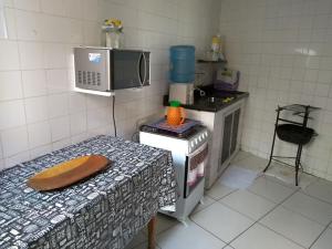 a kitchen with a microwave and a table in it at Casa na Praia do Forte in Cabo Frio