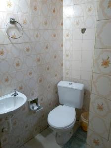 een badkamer met een wit toilet en een wastafel bij Casa na Praia do Forte in Cabo Frio