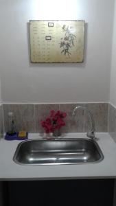 a kitchen sink with a picture on the wall at WAYRA TAKI (Canción del Viento) in San Fernando del Valle de Catamarca