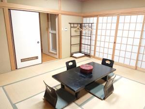 um quarto com uma mesa e cadeiras num quarto em Hotel Crown Hills Imabari em Imabari