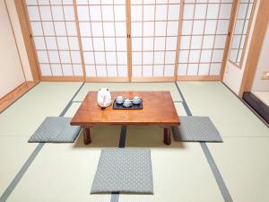a room with a wooden table and two mats at Hotel Crown Hills Imabari in Imabari