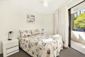 a bedroom with a bed and a window at Spinnaker Quays in Mooloolaba