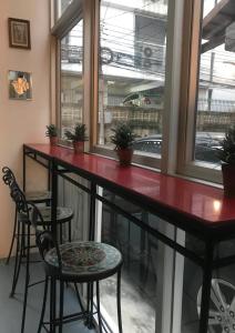 a bar with two chairs and a red counter at Oriental Smile Hotel in Bangkok