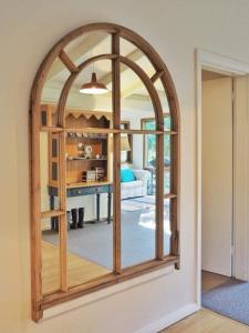 a large mirror in a room with a living room at Lark Cottage in Burrawang