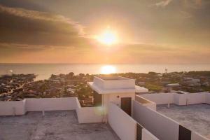 a view of the sunset from the balcony of a house at WindMill SunRise PaddyView Homestay in Sekincan