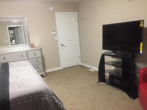 a bedroom with a television and a dresser with a mirror at Beautiful and Safe Home in Winnipeg