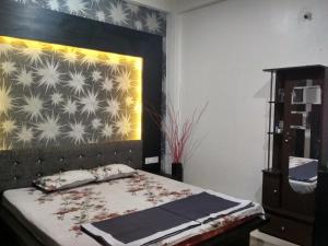 sypialnia z łóżkiem z zagłówkiem i ścianą w obiekcie Ashta Lakshmi Tourist Home Stay w mieście Indore