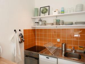 a kitchen with a sink and a stove at Ferienwohnung *Krabbe 25* in Wittdün +10 photos