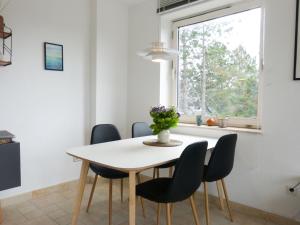 a dining room table with chairs and a window at Ferienwohnung *Krabbe 25* in Wittdün