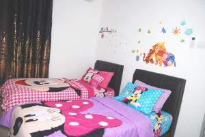 a bedroom with two twin beds with hello kitty pillows at Qstay Sitiawan Townhouse (Minnie Dreams) - 米妮梦 in Sitiawan