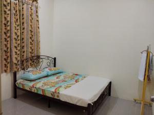 ein kleines Bett in einem Zimmer mit Vorhang in der Unterkunft Teratak Anakanda in Kuala Berang