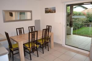 a dining room with a wooden table and chairs at Maison Lore Mendi Amotz in Saint-Pée-sur-Nivelle +12 photos