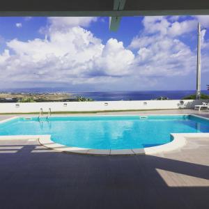 a large swimming pool with a view of the ocean at B&B Torrefano in Portopalo