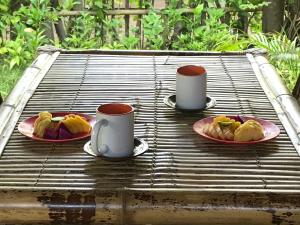 two cups and plates of food on a picnic table at Meno Madia Bungalows in Gili Meno