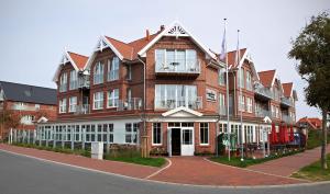 a large red brick building on a street at Logierhus Langeoog in Langeoog