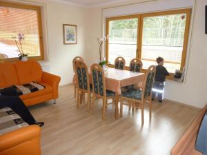 Un niño parado en una mesa de comedor con un ordenador portátil en Vronis Landhaus Apartments en Hüttau