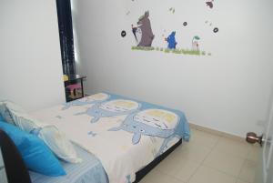 a bedroom with a bed with two pillows on it at Qstay Sitiawan Townhouse (Totoro Dreams) - 梦见龙猫 in Sitiawan