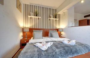 sypialnia z łóżkiem z dwoma białymi kwiatami w obiekcie Safir przy samym WYCIĄGU w mieście Karpacz