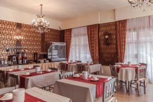 restauracja ze stołami i krzesłami oraz żyrandolem w obiekcie Hotel Marisa w Albendze