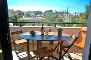 una mesa con una botella de vino en el balcón en Kissonerga Apartment, en Pafos