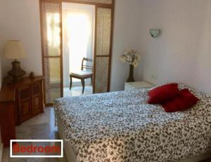 ベナルマデナにあるPuerto Marinaのベッドルーム1室(赤い枕のベッド1台付)