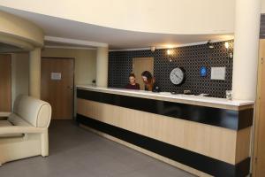 two women standing at a counter in a hotel lobby at Hotel Sunny in Poznań