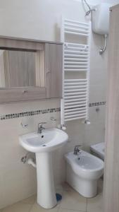 bagno bianco con lavandino e servizi igienici di Appartamento B&B Domus Pompei a Scafati