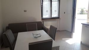 un tavolo bianco con sedie e ciotola sopra di Appartamento B&B Domus Pompei a Scafati
