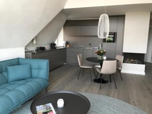 a living room with a blue couch and a table at Lerchenhof in Wenningstedt