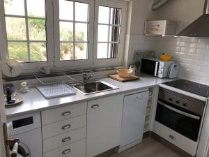a kitchen with a sink and a microwave at Salty House - Casa Salgada in Foz do Arelho