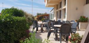 a row of tables and chairs on a patio at Hotel Corallo in Fregene