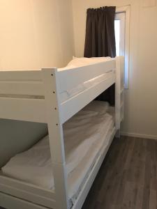 a white bunk bed in a room with a window at Fjordgård B in Tofta