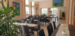 a restaurant with tables and chairs in a room at Hotel Corallo in Fregene