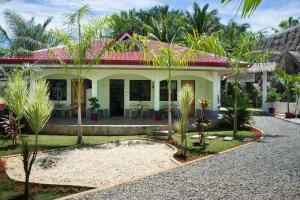 una casa con palmeras delante en The Three Shooting Stars, en Panglao