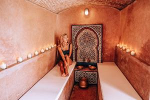 una mujer sentada en una habitación con bañera en Riad Ksar Fawz & Spa en Marrakech