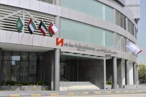 um edifício com bandeiras na lateral em Swiss-Belresidences Juffair em Manama